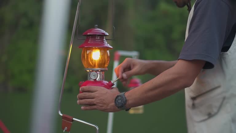 Close up hand of A man lanterns are lit lantern for light. Outdoor Camping Concept.