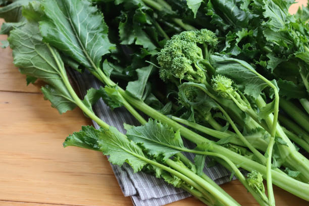 Fresh turnip plants. Italian cime di rapa with green leaves and blossoms on table Fresh green turnip plants. Italian cime di rapa with green leaves and blossoms on wooden table. Brassica rapa var. cymosa brassica rapa stock pictures, royalty-free photos & images