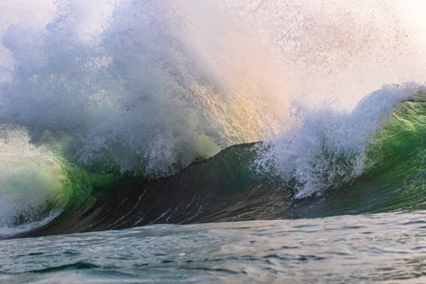 istock Large ocean waves colliding creating an explosive water pattern in warm golden light 1471577719