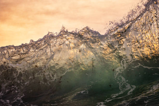 istock Close up of ocean waves colliding creating pattern in warm golden light 1471577807