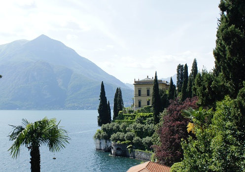 ancient noble house on Lake Como where famous American Hollywood films were shot. Garden and boathouse. Palm trees and cypresses.