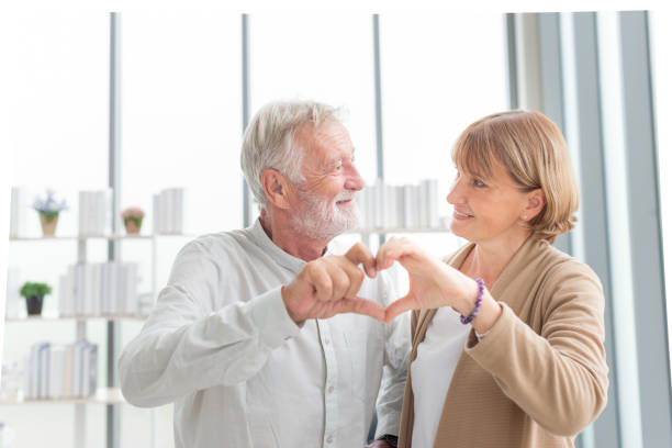 istock Elderly couple. Joyful nice elderly couple smiling while being in a great mood. Beautiful senior couple embracing each other, sitting on the couch at home 1471583486