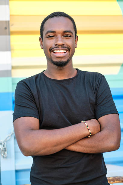 istock Confident man smiling while standing with crossed arms outdoors. 1471583540