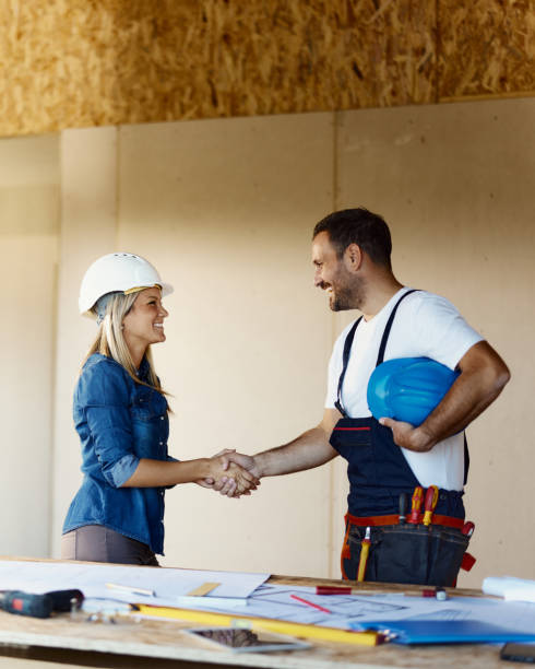 istock Happy worker greeting female inspector at construction site. 1471584554