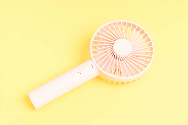 istock Small portable fan on yellow background close-up, copy space. 1471585259