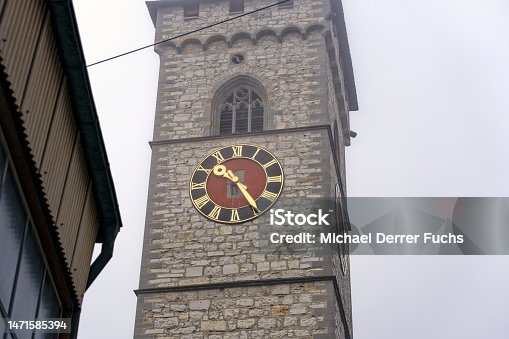 istock Stone church tower of church St. Johann with clock face at the old town of Swiss City of Schaffhausen on a foggy winter day. 1471585394