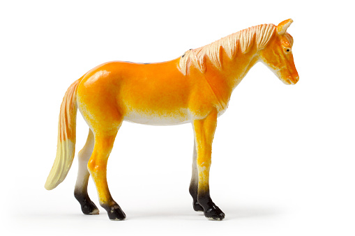 A figure of a red horse on a white background. Toy horse close-up.