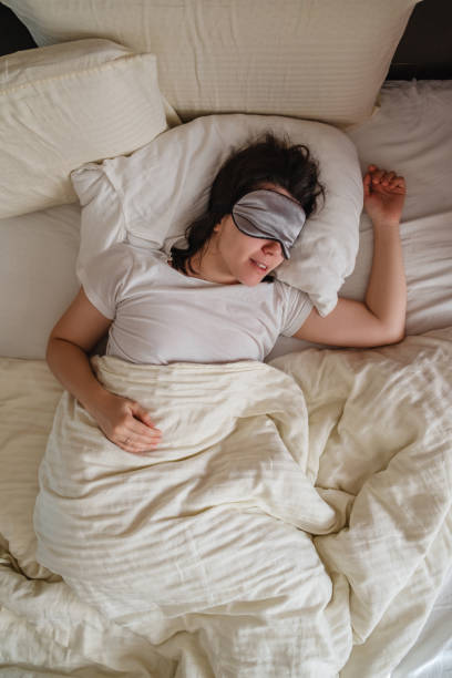 istock Top view of smiling woman waking up in white sheets 1471585749