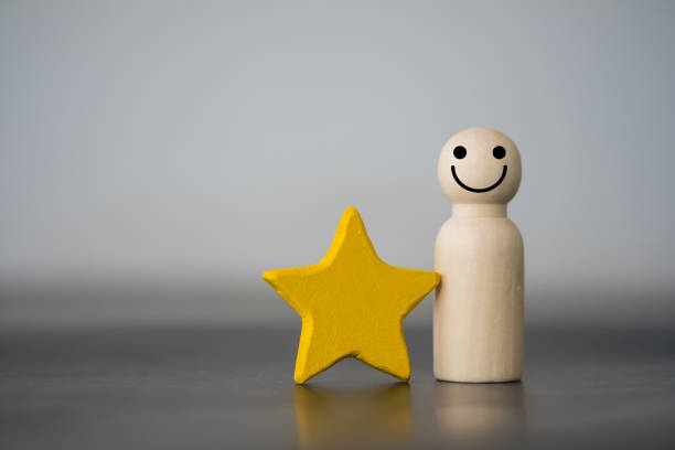 黄色い星と一緒に立っている木像のペグ人形。人材、人材 - 褒美 ストックフォトと画像