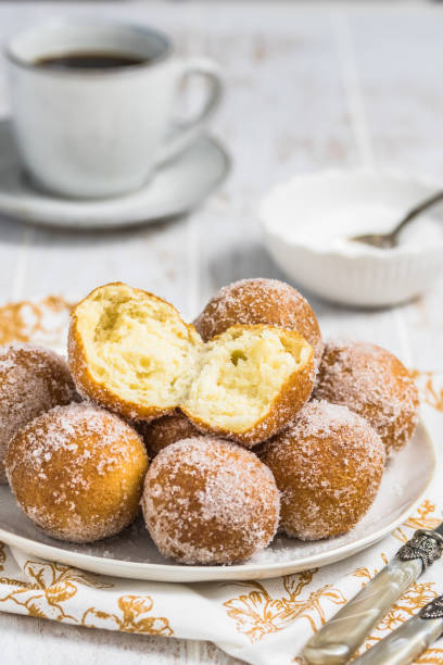 istock Fried curd balls with sugar on a white plate on white wooden background, vertical 1471587160