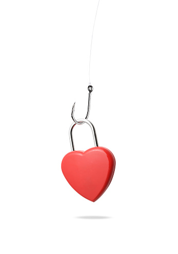 Close-up of heart shaped padlock with fishing hook against white background.