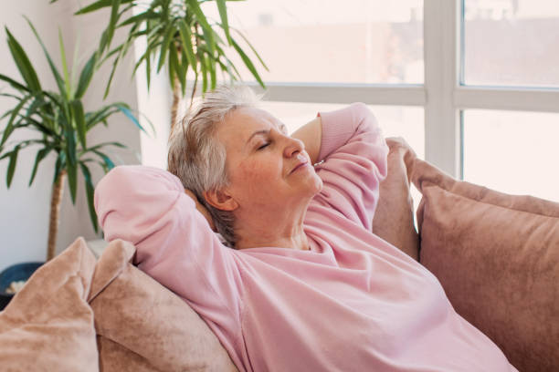 istock Relaxed satisfied older woman sitting leaning back on couch 1471590341