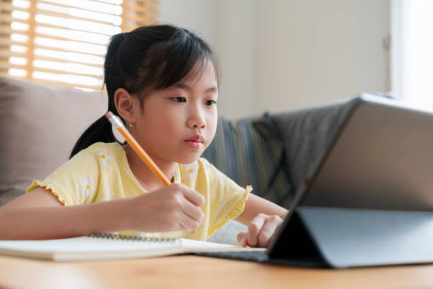 istock Asian little girl doing homework at home 1471591749