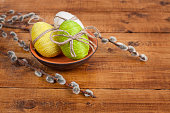 Easter eggs with willow branches on a wooden table