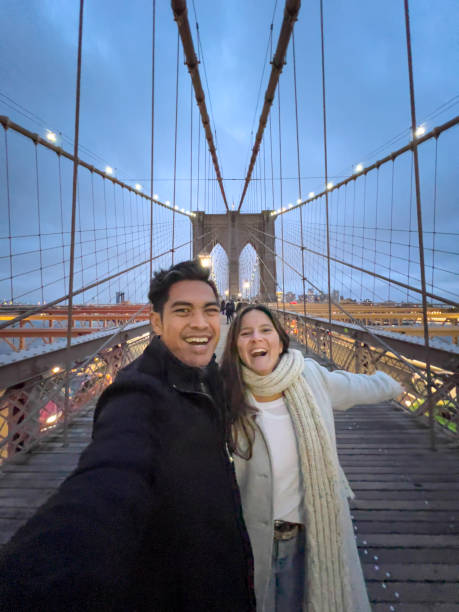 istock Cheerful couple taking selfie on Brooklyn bridge at dusk 1471592425