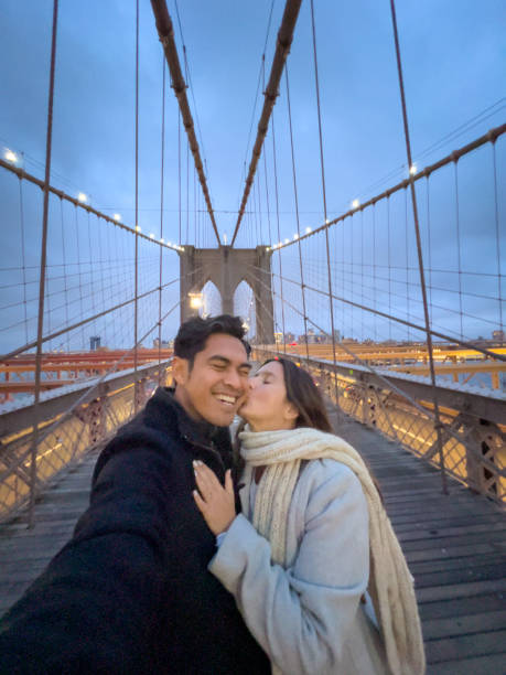 istock Cheerful couple taking selfie on Brooklyn bridge at dusk 1471592447
