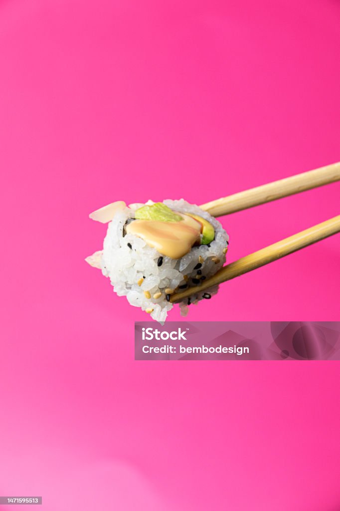 Uramaki Sushi with chopsticks on a pink background Box - Container Stock Photo