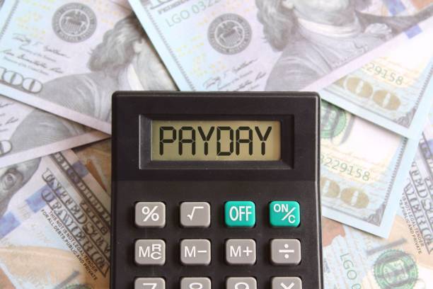 istock Top view image of money and calculator with text PAYDAY 1471595853