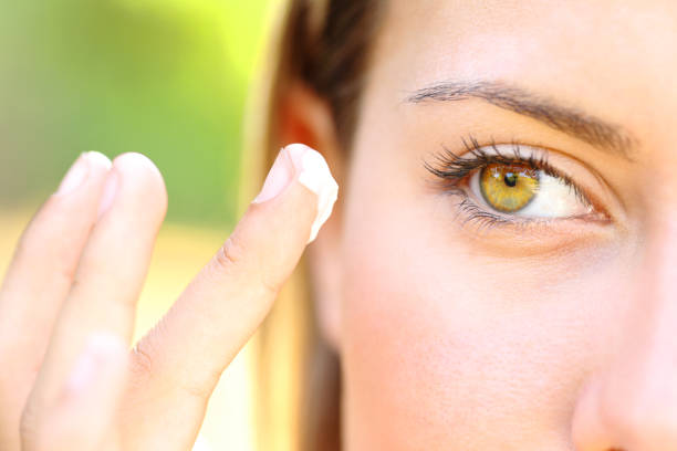 istock Woman with beauty eyes applying moisturizer 1471598478