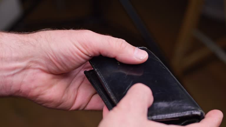 A man looks into an empty wallet. Inflation took all the money, unemployment in the labor market.