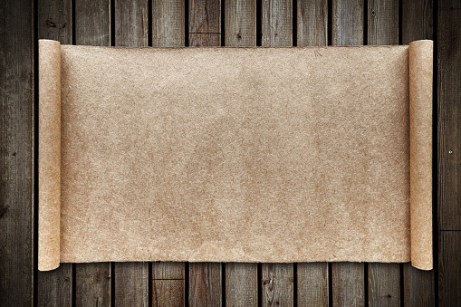 Blank brown scrolling paper on wood background.