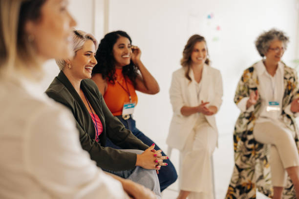Multicultural businesswomen having a conference meeting in an office Multicultural businesswomen smiling cheerfully during a conference meeting in a modern workplace. Group of successful businesswomen working together in an all-female startup. only women stock pictures, royalty-free photos & images