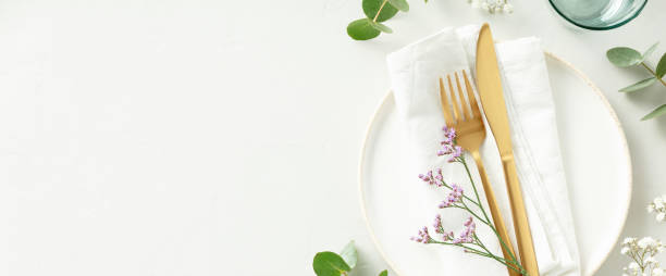 istock Gold Cutlery with eucalyptus branches on white plate with napkin over light grey Background. Minimalistic design. Copy Space banner 1471601818