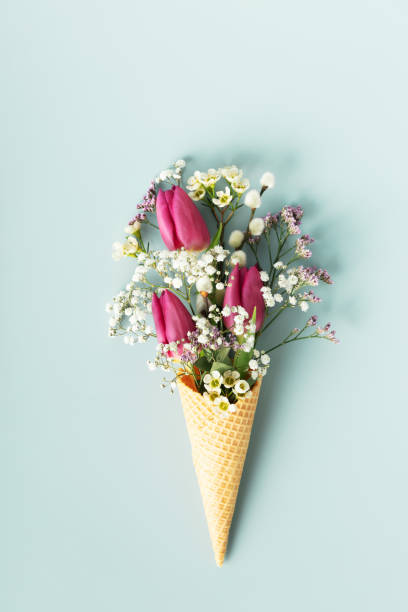 istock Ice cream cone with beautiful flowers on blue background flat lay 1471602047