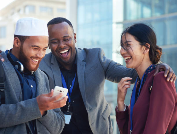 Diverse business people using smartphone friends laughing looking at mobile phone in city diversidad, gente divertida o de negocios con teléfono en la ciudad para redes sociales, contenido de blog o meme cómico de internet. feliz, sonríe o amigos en el teléfono inteligente 5g riendo, comunicándose o estableciendo contactos al aire libre