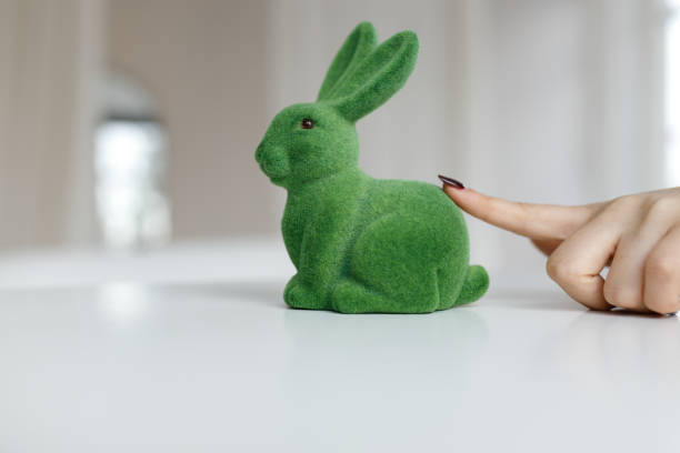 Easter bunny rabbit statuette. The girl touches the Easter bunny. Close up, copy space.
