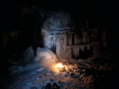 Firework illuminating a frozen Waterfall in the Swiss Alps, captured in the night.