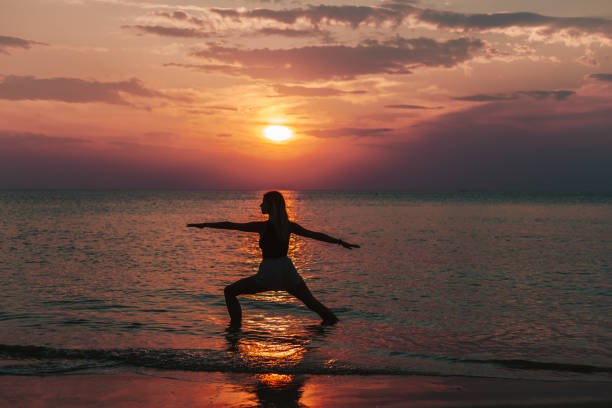 istock Woman practicing yoga on a beach during sunset 1471607965