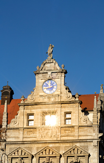 Top of the tower's clock of Leipzig City Hall when the sun hits directly on a window making an interesting light effect