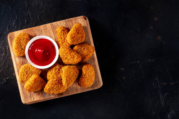 Chicken nuggets with ketchup on a dark background, shot from the top stock photo