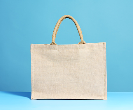 Beige cotton tote bag for mock up on a light blue background