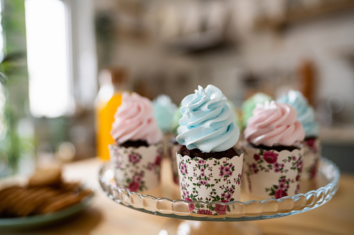 Cupcakes with blue and rose colored whipped cream, for a gender reveal party