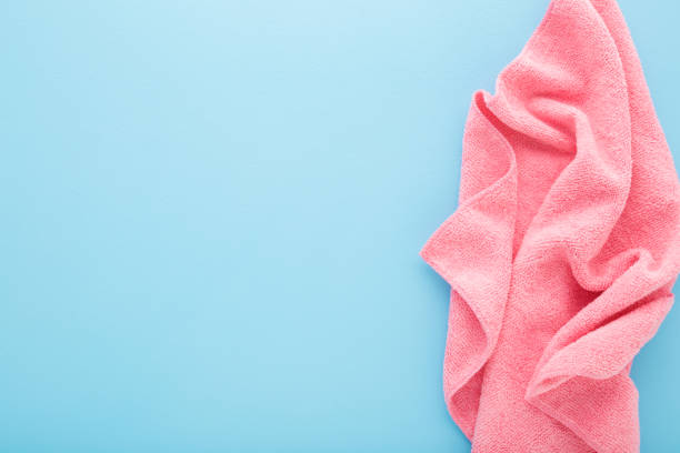 istock Pink wrinkled dry soft microfiber rag for different surfaces wiping on light blue table background. Pastel color. Closeup. Empty place for text. Top down view. 1471613178