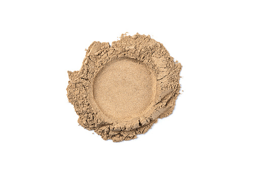 Crumbled natural face powder sample isolated on white background. Abstract beige face powder smear for design.