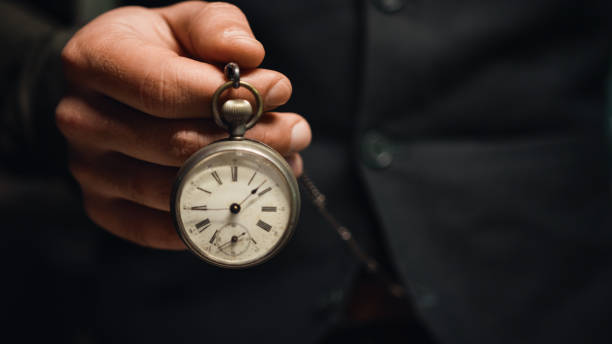 istock Man holds pocket watch in hand 1471618163