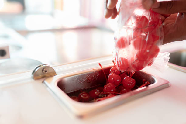 istock An ice-cream parlor worker is dropping some cherry toppings into the counter tray 1471618284