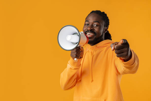 istock Young african man against yellow background with megaphone 1471618831