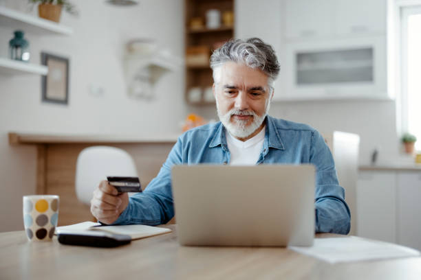istock Man using credit card and laptop at home 1471620567