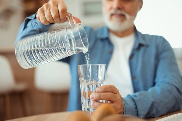istock Man Pouring Water Into Glass 1471621449