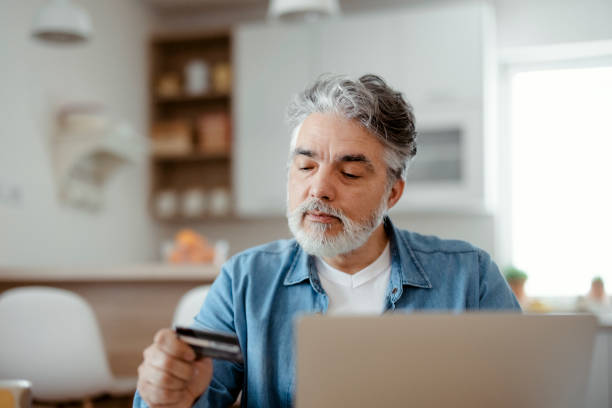 istock Man using credit card and laptop at home 1471621831