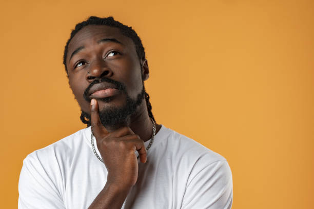 istock Young african guy thinking about something over yellow background 1471621864