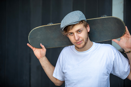 Portrait of skateboarder on dark background