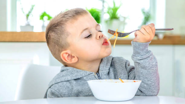 istock children in the kitchen at the table eat pasta. 1471622149