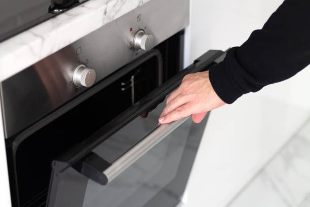 istock Man open modern electric oven, making dinner at home concept 1471622154