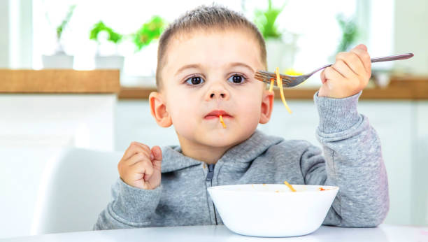 istock children in the kitchen at the table eat pasta. 1471622159