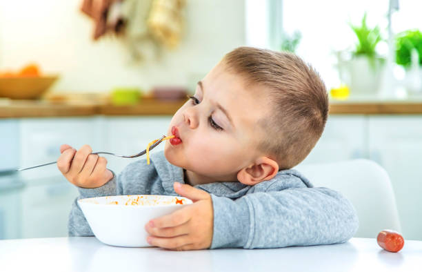 istock children in the kitchen at the table turning pasta. 1471622190